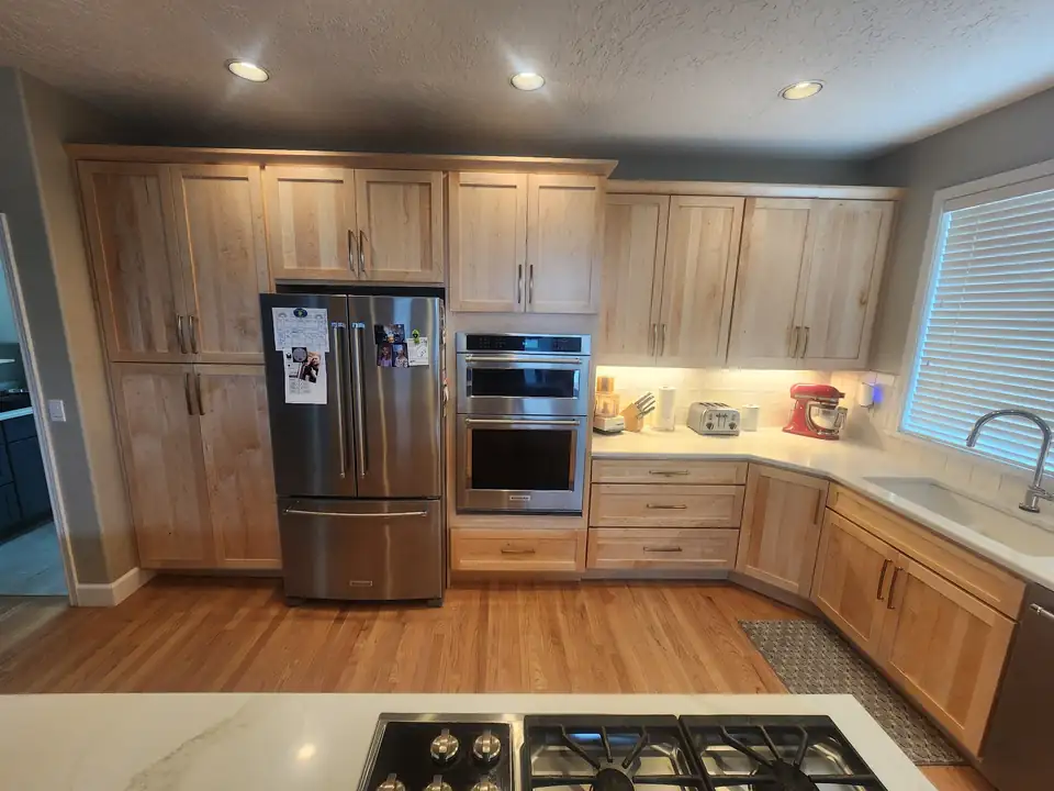 Kitchen remodeling Gresham OR project with natural maple cabinets, stainless refrigerator and double wall ovens in a U-shaped layout