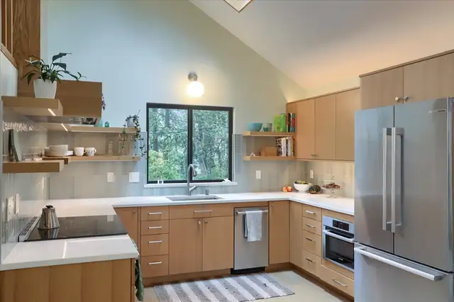 Vancouver, WA kitchen from a combined kitchen and bath remodel, with flat-panel wood cabinets, floating shelves and a stainless refrigerator